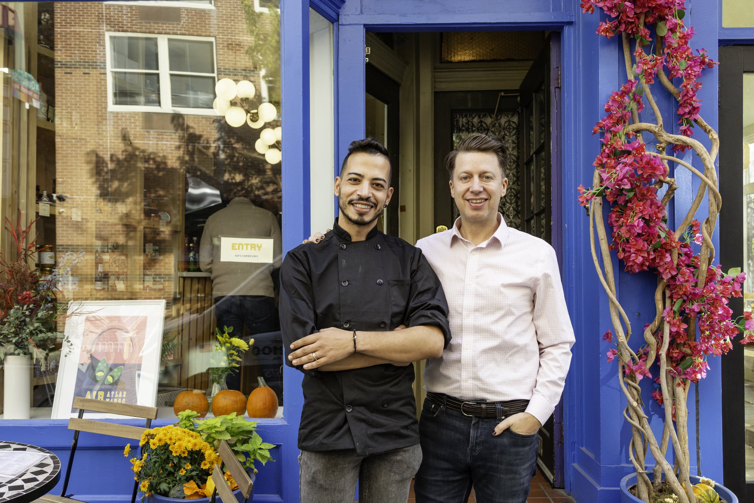 Soufiane and Christophe outside the blue entrance of Sofi Corner Café